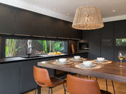 Cocina oscura con vistas al jardín