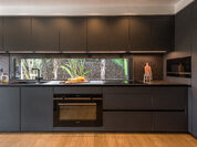 Cocina oscura con vistas al jardín